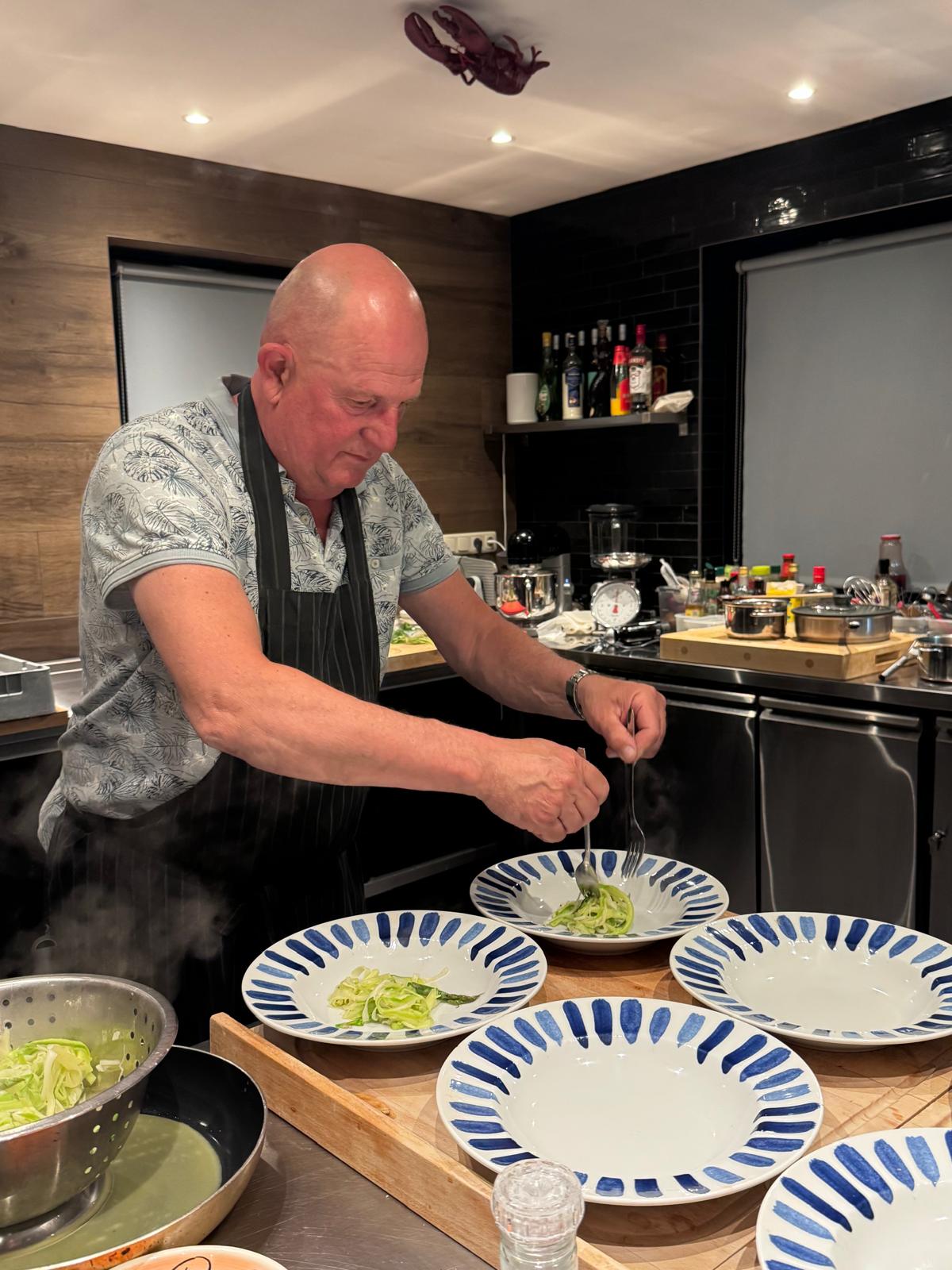 Een kel draait pasta met de vork voor het opmaken.
